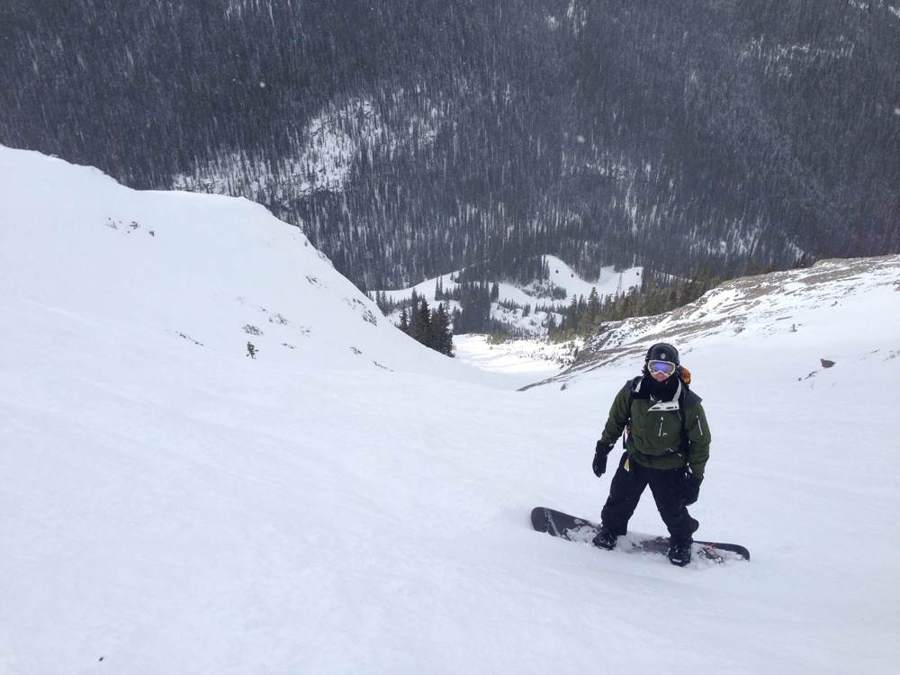 Snowboarder riding soft snow in a gully